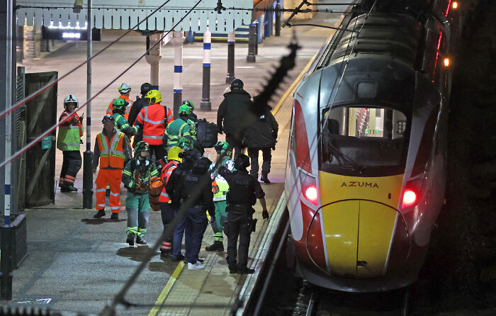 Emergency responders and police gather on a UK train platform during chaos after a knife attack was blocked by a heroic old man.