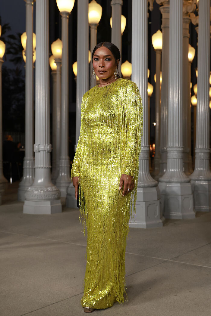 Woman in a sparkling yellow fringe gown posing at the 2025 LACMA Art and Film Gala showcasing standout outfits.
