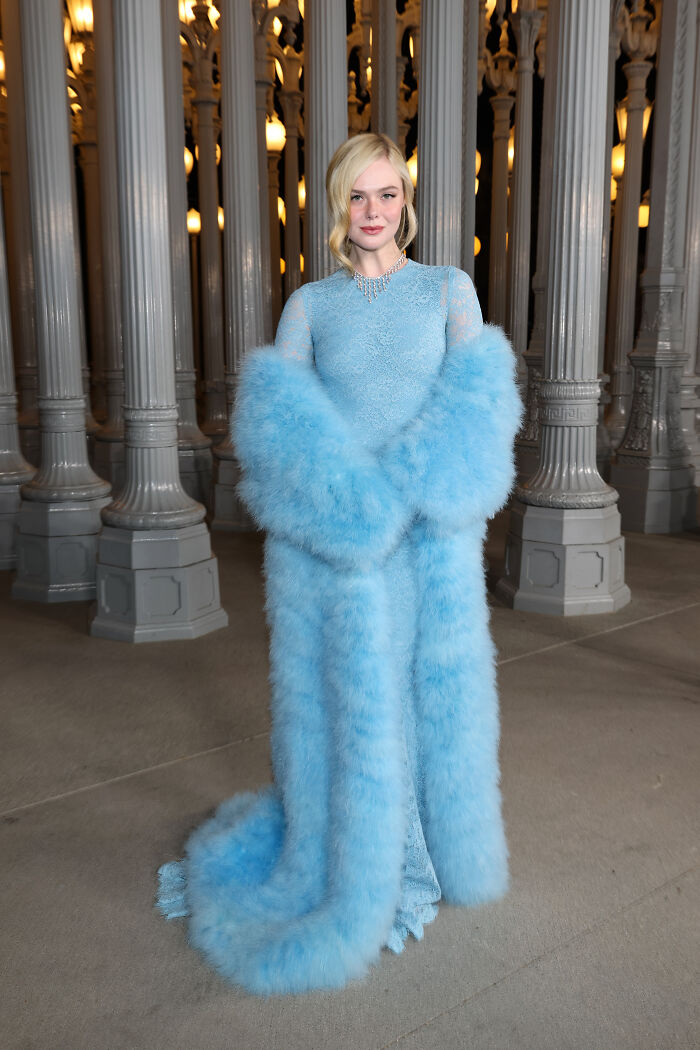 Woman in elegant blue lace dress with matching fluffy stole posing at 2025 LACMA Art and Film Gala fashion event.