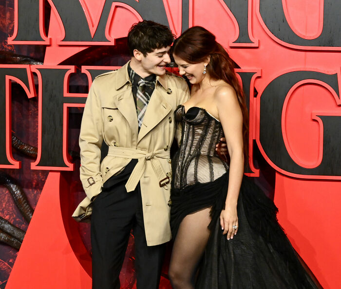 Millie Bobby Brown wearing lingerie with a train-style dress at the Stranger Things red carpet event.