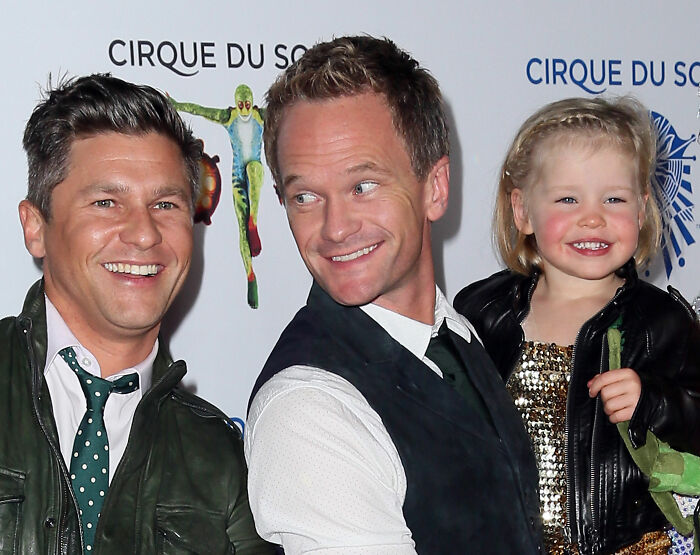 Neil Patrick Harris with a smiling young girl and another man at a Cirque du Soleil event.