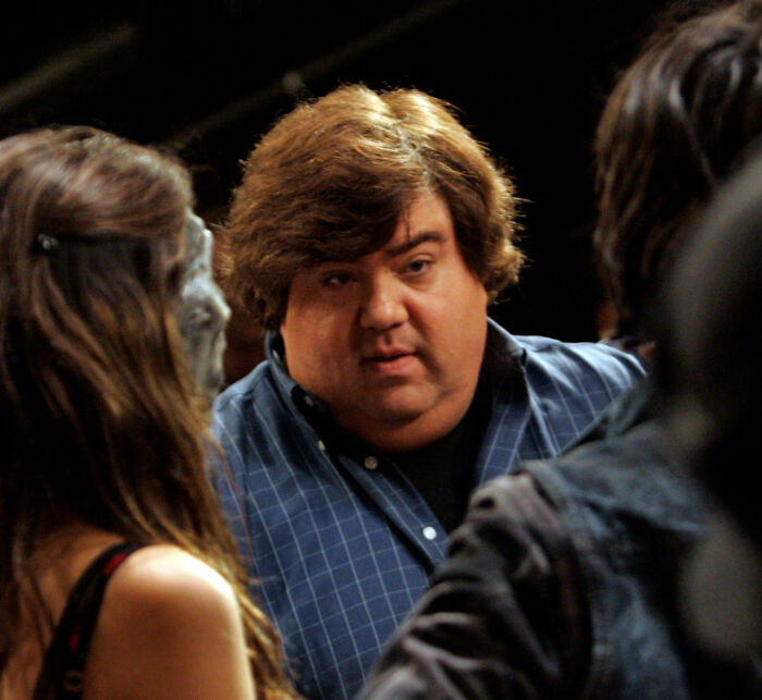 Man with brown hair wearing a blue shirt in conversation, related to Amanda Bynes breaking silence after viral claim.