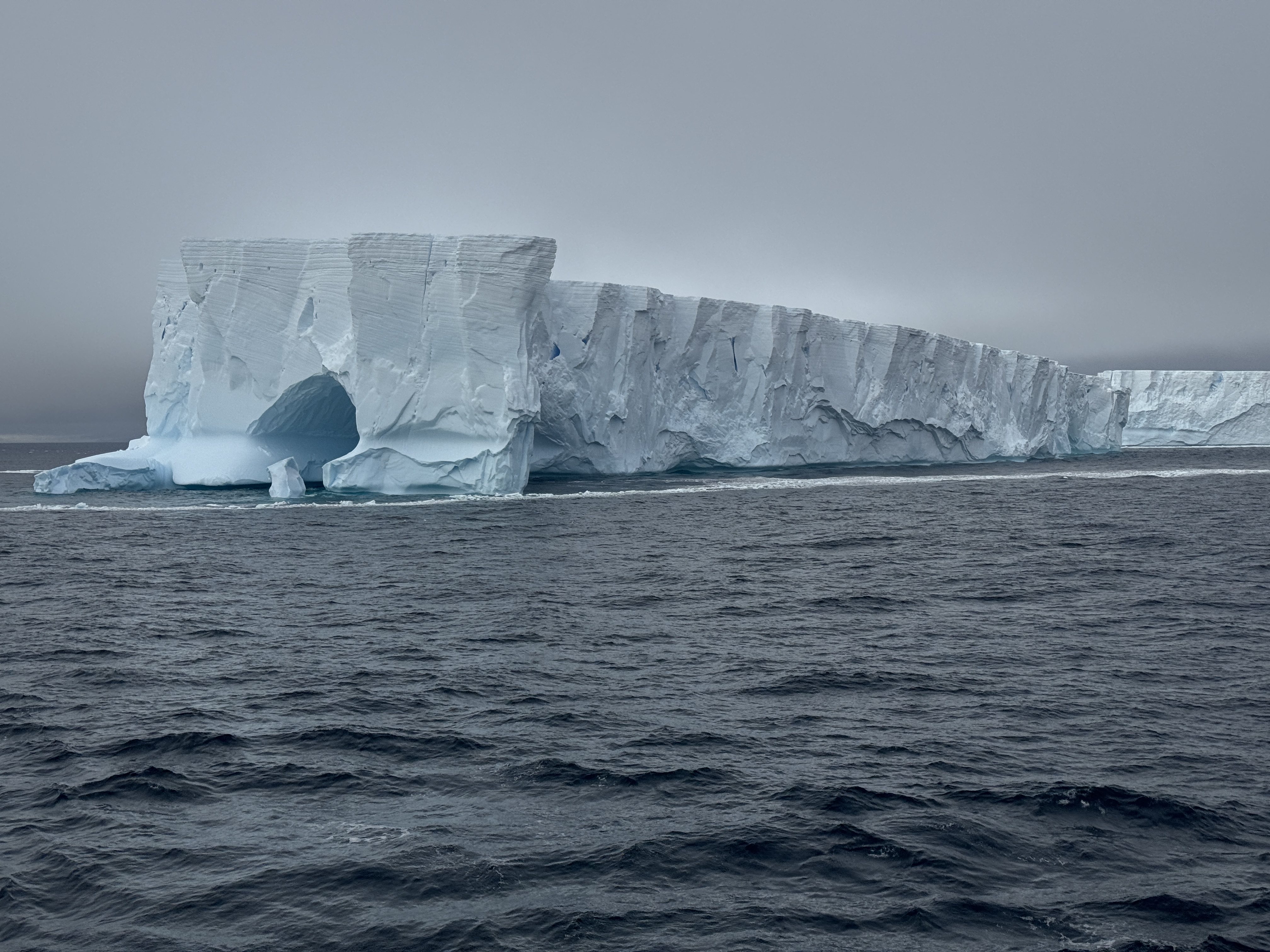 Massive iceberg floating in dark ocean waters showcasing the scale and beauty of Antarctica's icy landscape. Massive iceberg floating in dark ocean waters showcasing the scale and beauty of Antarctica's icy landscape.