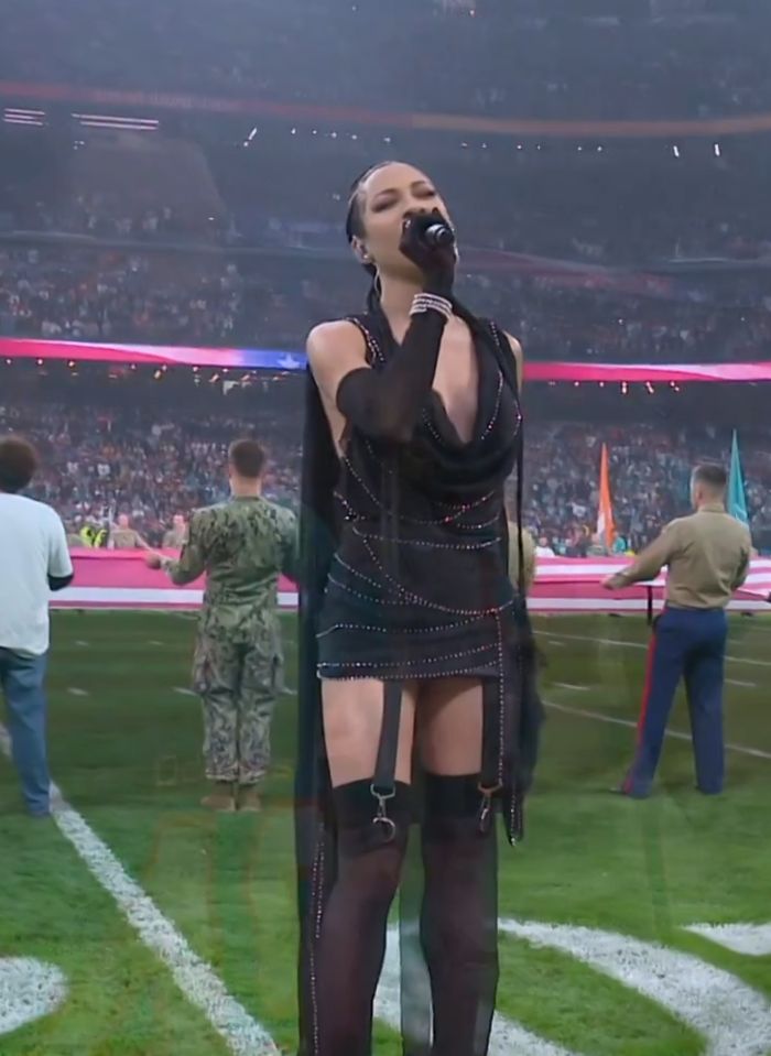 Singer performing in a revealing outfit during the US national anthem at an NFL game amid controversy.