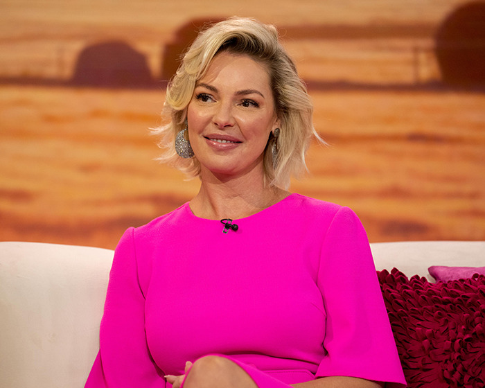 Actress in a bright pink dress sharing stunning confessions about their movies during a televised interview.