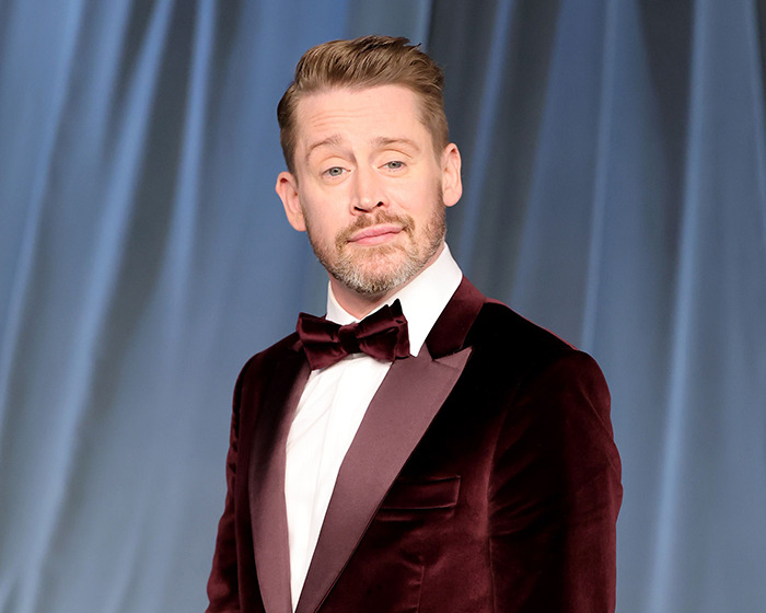 Actor in a burgundy velvet tuxedo and bow tie posing confidently, related to celebrities stunning confessions about movies.