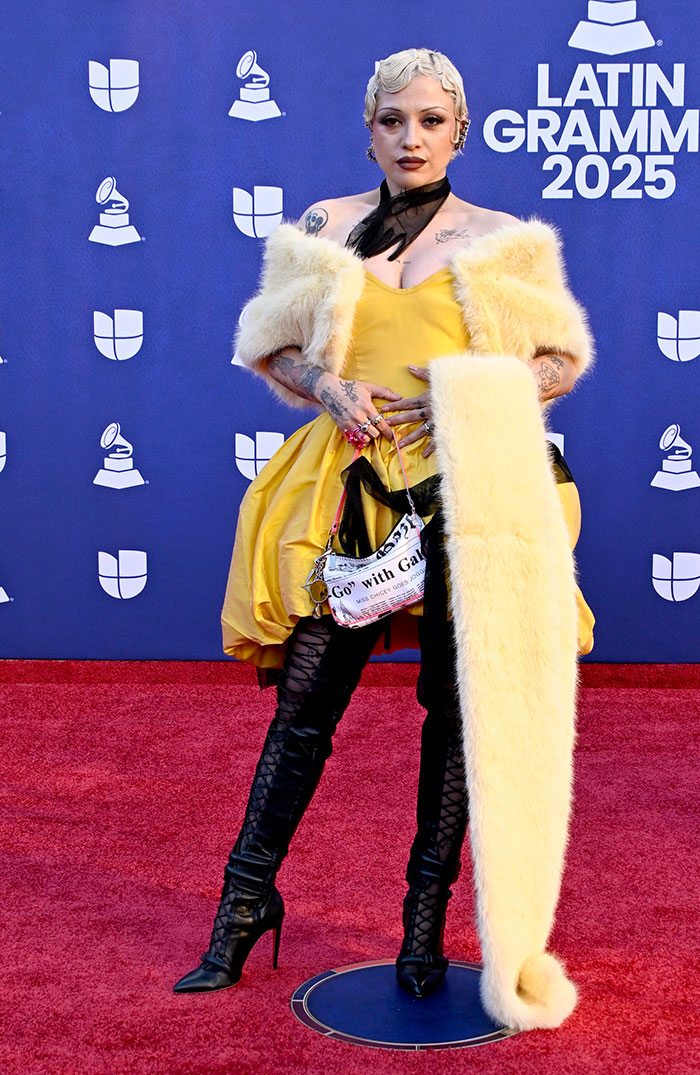 Female star in a yellow dress and fur stole posing on the red carpet at the worst dressed stars Latin Grammy 2025 event