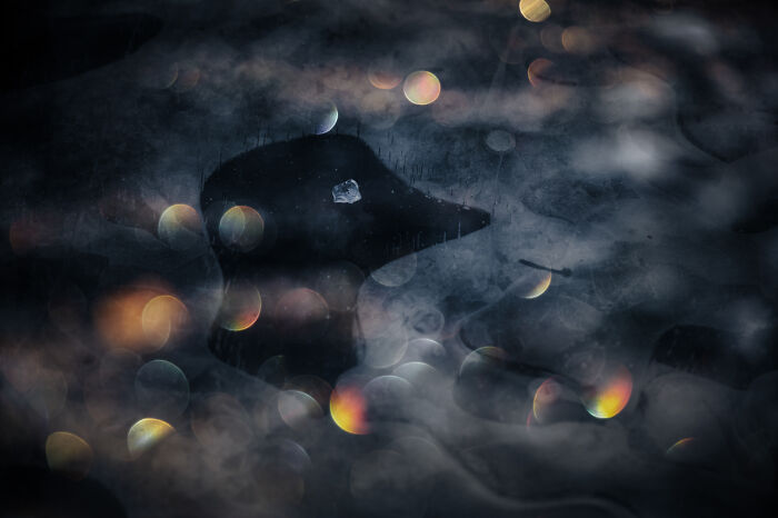Abstract nature photo with dark water, light reflections, and mist creating a magical atmosphere in award-winning nature photos.