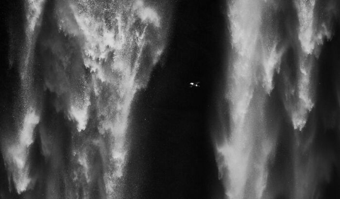 Black and white photo of powerful waterfall spray capturing the magic of nature in an award-winning nature photo.