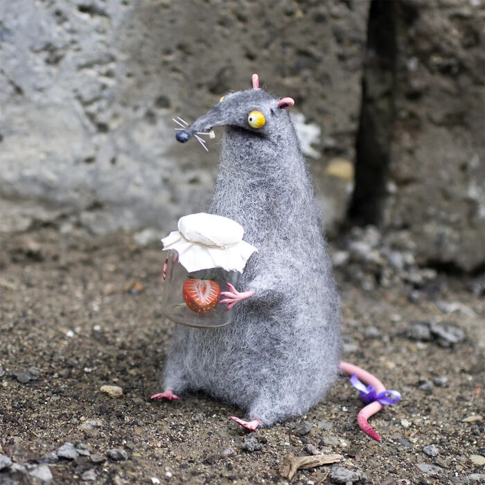 Adorably strange handmade creature toy resembling a gray rat holding a jar with a strawberry inside.