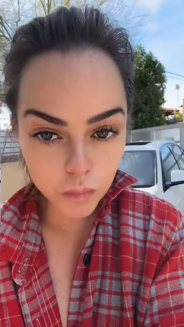 Close-up of Taryn Manning wearing a red plaid shirt outdoors, fans concerned after strange video appearance.