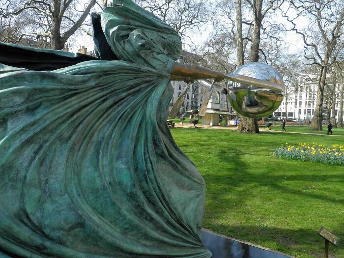 Bronze and metallic modern sculpture in a park setting, showcasing spectacular sculptures across the globe for travel enthusiasts.