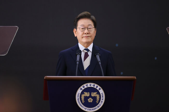 South Korean man known as world&rsquo;s smartest standing at podium with presidential emblem, speaking publicly.