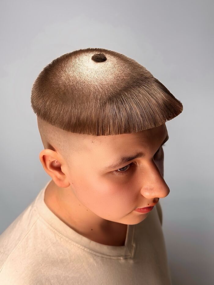 Unique bold barber haircut featuring a geometric shaved design with a circular pattern on top and a sharp fringe edge.