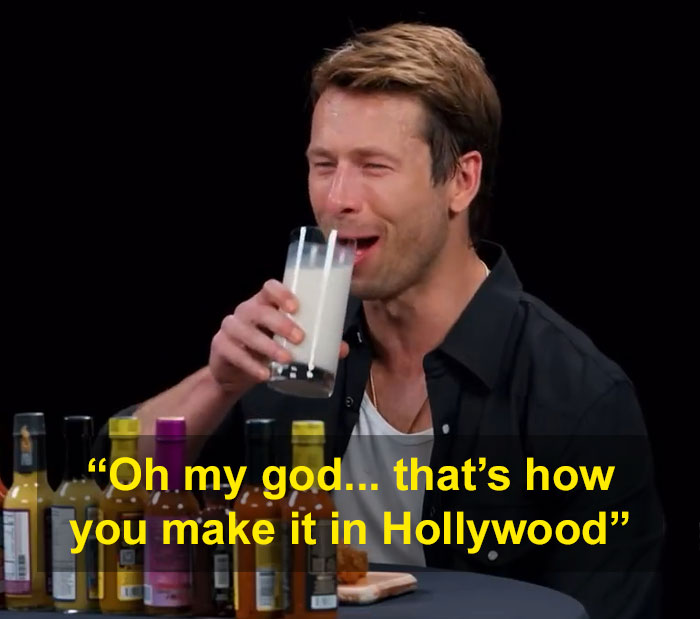 Glen Powell during viral interview blunder, holding a glass of milk, highlighting Hollywood's dark side exposure.