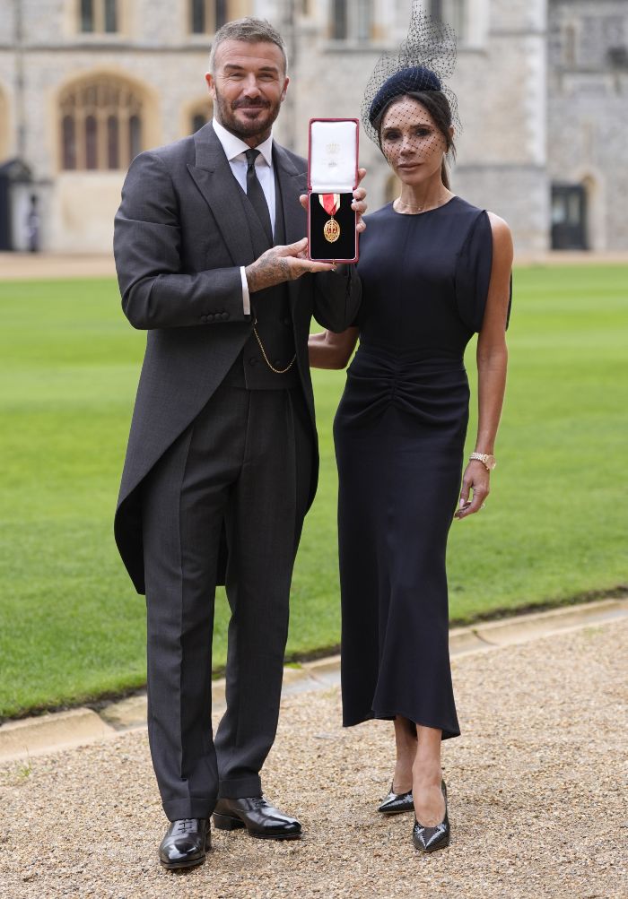 Victoria Beckham and David Beckham outdoors, David holding Sir title medal in a formal setting after honor ceremony. Victoria Beckham and David Beckham outdoors, David holding Sir title medal in a formal setting after honor ceremony.