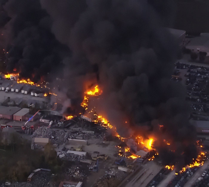 Thick black smoke and fire rising from the wreckage of a UPS plane crash with multiple casualties reported.
