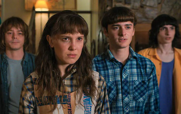 Stranger Things star with co-actors in a scene highlighting bullying faced by Millie Bobby Brown in a dramatic setting.