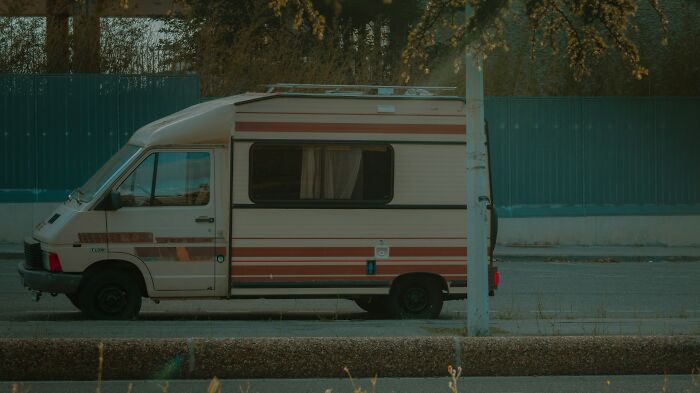 Vintage camper van parked by the roadside under trees, illustrating absurd but true stories about receiving unexpected tips.