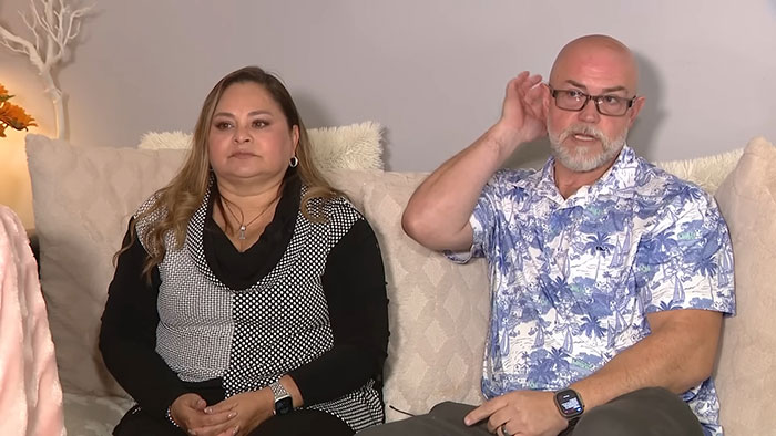 Couple sitting on a couch discussing the woman born without most of her brain as family speaks out on her 20th birthday.