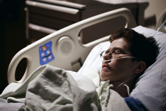 Patient resting in hospital bed with oxygen tube, evoking eerie moments patients said that still haunt doctors today.