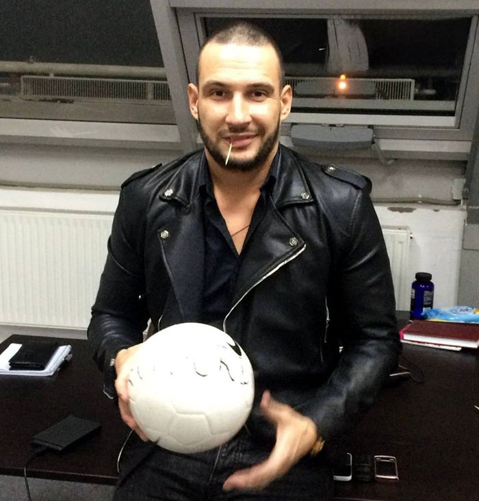 Man in a black leather jacket holding a soccer ball, linked to a crypto scammer behind a $500M scheme in Dubai.