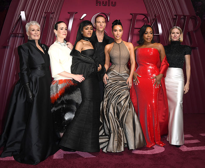 Cast members at the All's Fair premiere with Kim Kardashian posing on the red carpet in elegant gowns and suits.