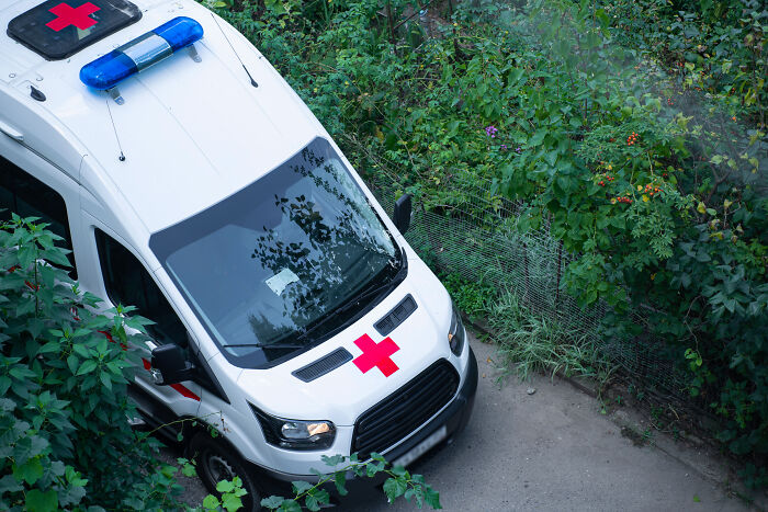 Ambulance parked on a narrow path surrounded by greenery, symbolizing eerie patient stories that haunt doctors.
