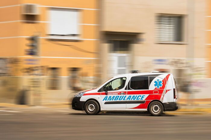 Ambulance speeding on city street, symbolizing emergencies and worst things seen on Black Friday by employees.