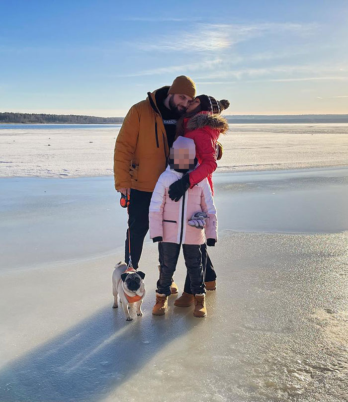 Family dressed warmly standing on frozen lake with dog, unrelated to crypto scammer behind 500M scheme in Dubai news.