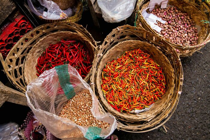 Baskets of colorful chili peppers and nuts at a market, highlighting unexpected and wild tip stories.