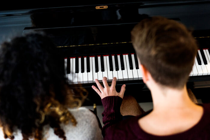 Two people playing piano together, illustrating funny or insane things patients said or did under anesthesia effects.