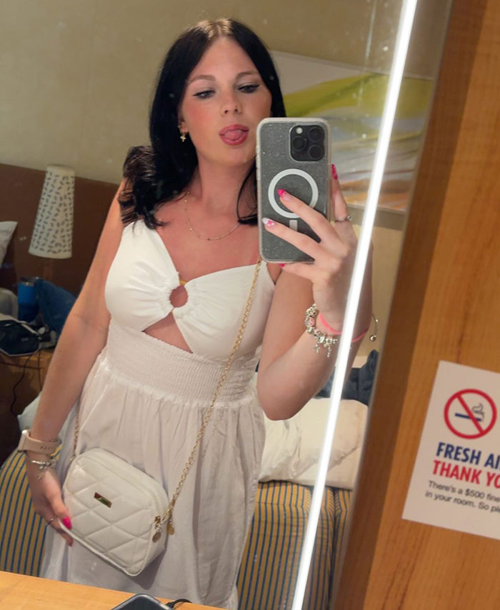 Young woman taking mirror selfie in white dress, stepsibling under investigation after teen&rsquo;s body found on Carnival Cruise.