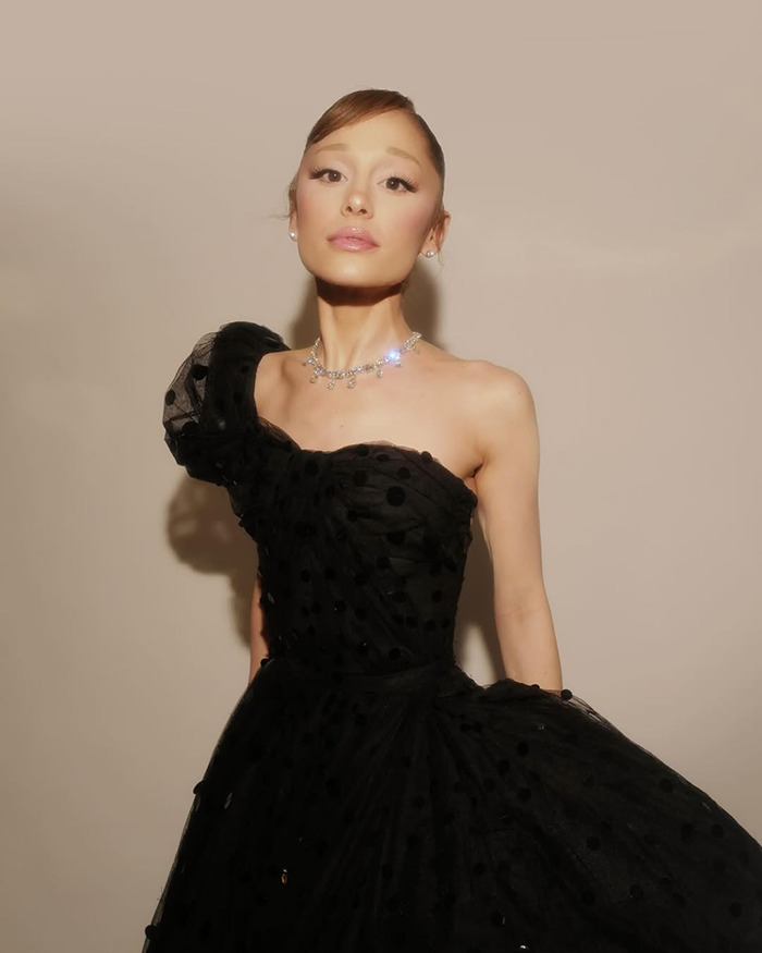 Ariana Grande in a black dress and sparkling necklace, making a cryptic last hurrah announcement to heartbroken fans.