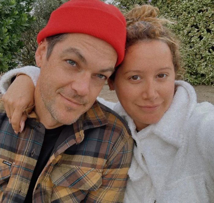 Ashley Tisdale posing outdoors in casual wear, sharing a moment as she makes name change official with explanation.