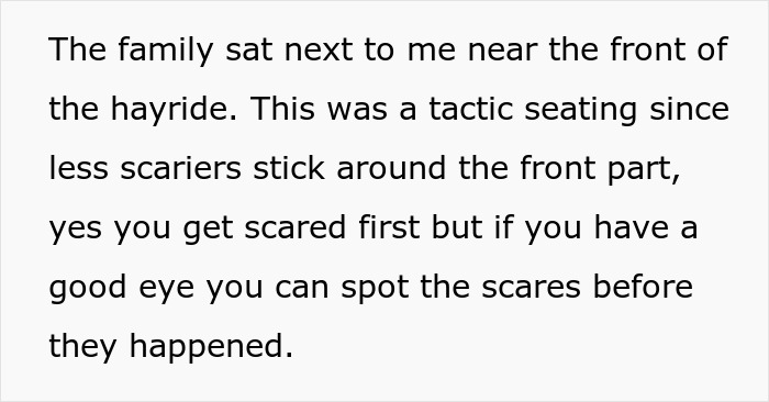 Family sitting near the front of a haunted hayride using a tactic to avoid scares and protect scared kids.