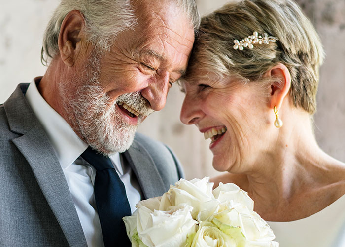Happy elderly couple laughing together, sharing a joyful moment in a candid family drama scene.