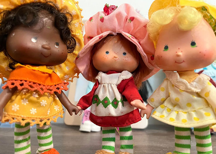 Three vintage dolls with colorful outfits and striped stockings representing family dramas that make relatives seem normal.