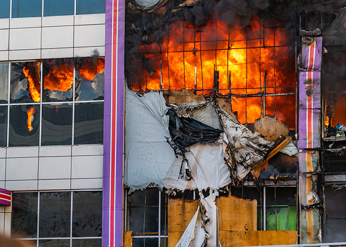 Burning building with intense flames and damaged exterior, illustrating wild family dramas that make relatives look normal.