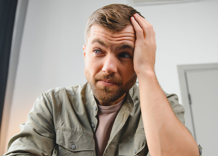 Man with beard looking confused and stressed, holding his head in a moment that wasn’t what it looked like.