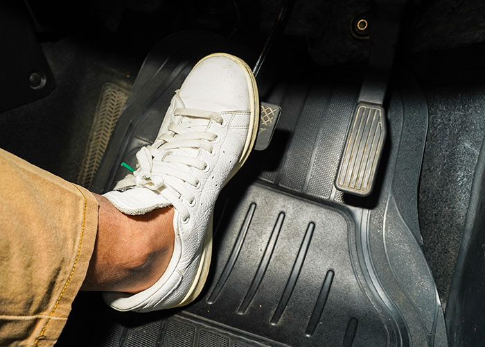 Person wearing white sneaker pressing a car brake pedal, capturing a crazy moment that wasn’t what it looked like.