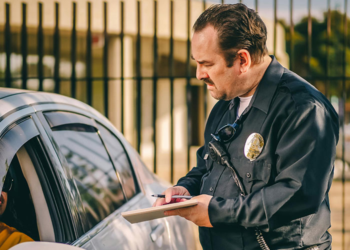 Police officer writing a ticket during a traffic stop, capturing a moment that wasn’t what it looked like.