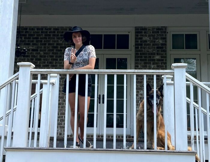 Young woman wearing a black hat stands on a porch with a dog, illustrating insider experiences of nepo babies.