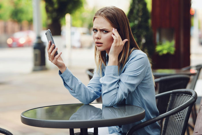Woman looking upset while holding phone outdoors, representing guy cheats on wife and affair child demands. Woman looking upset while holding phone outdoors, representing guy cheats on wife and affair child demands.