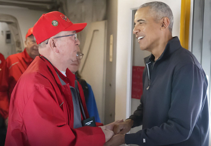Barack Obama warmly shaking hands with war veterans on a plane, capturing their emotional and heartfelt reactions.