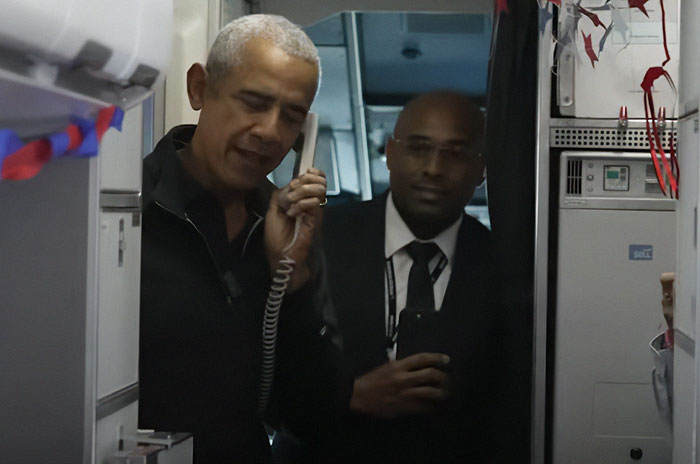 Barack Obama speaking on plane intercom, surprising war veterans with emotional reactions captured onboard flight.