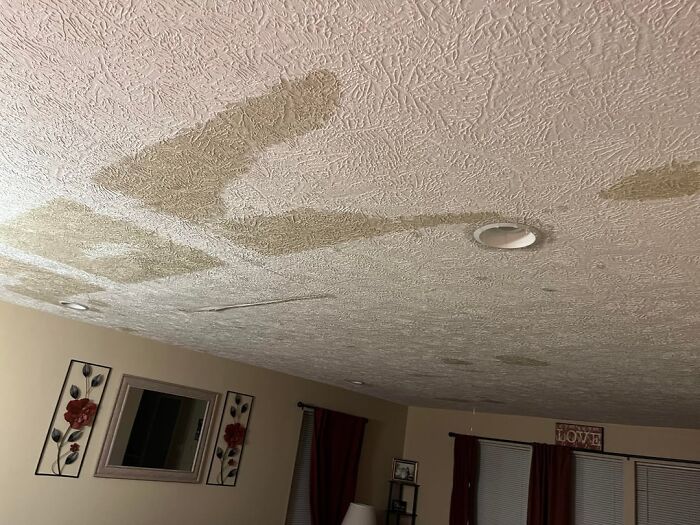 Ceiling with large water stains in a living room, highlighting common home issues many internet users think is a scam.
