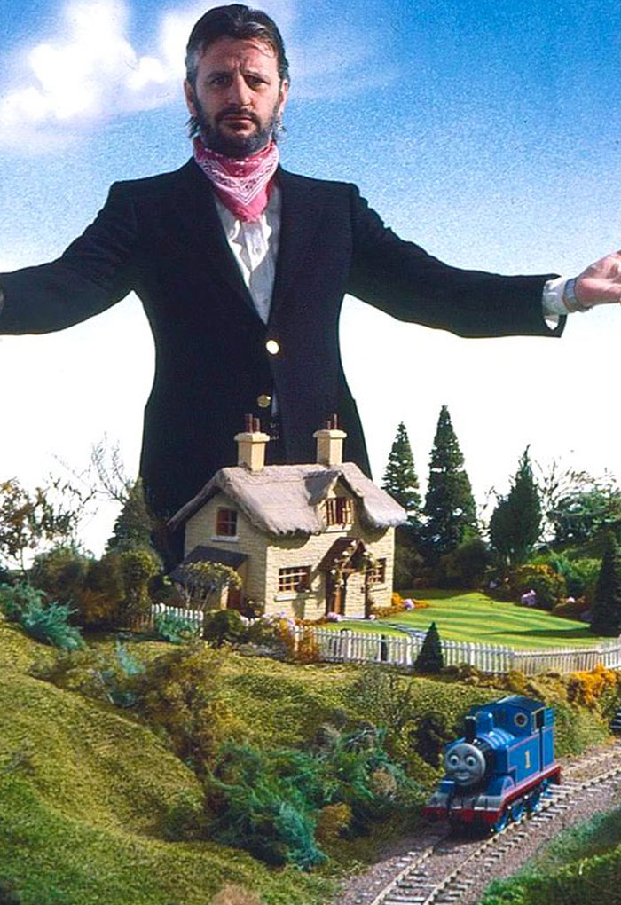 Man posing behind a miniature house and train set in unhinged behind-the-scenes photos meme moment.