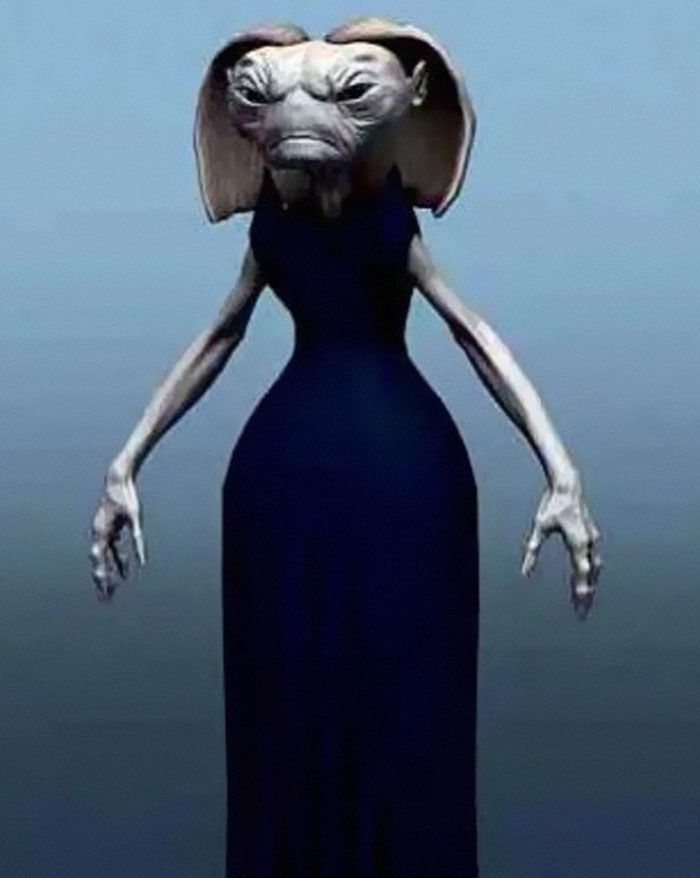 Alien creature in a form-fitting dark dress with exaggerated hips in an unhinged behind-the-scenes photo meme moment.