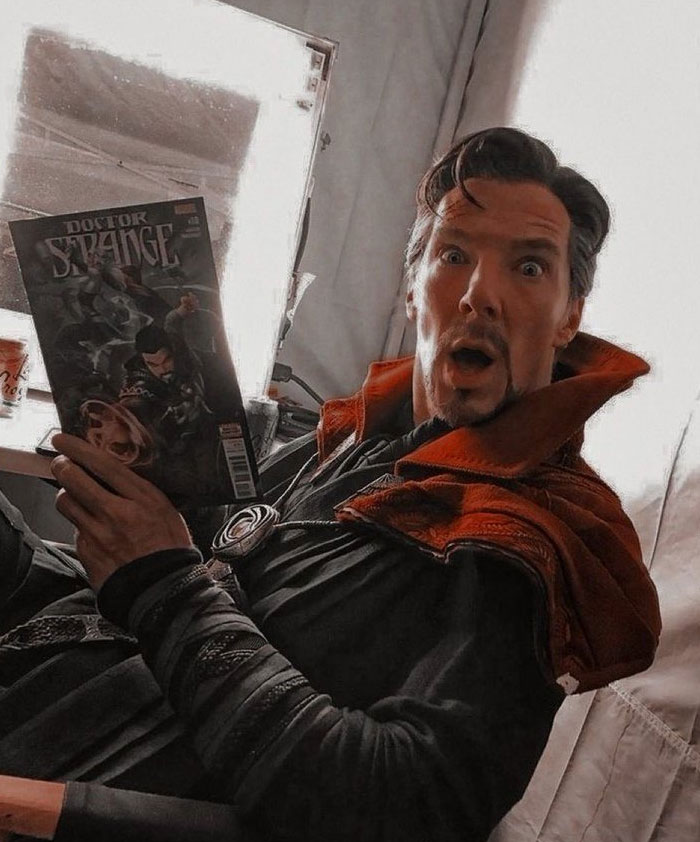 Actor dressed as Doctor Strange holding a comic book with an unhinged behind-the-scenes photo meme expression.